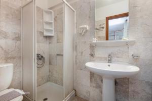 a bathroom with a sink and a toilet and a shower at Thimeli Hotel in Lygourio