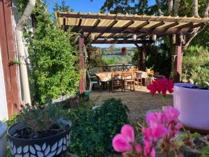 a wooden pergola with a table and some flowers at Gîte chez Kus in Changey +3 photos