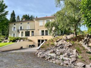 a large house with a rock wall in front of it at Domaine de la Brême in Bréménil