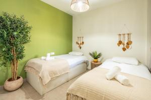 two beds in a room with green walls at Bayview Hills Apartamento Andaluz in Torrox +14 photos