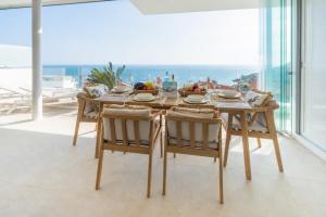 a dining room with a table and views of the ocean at Bayview Hills Apartamento Andaluz in Torrox