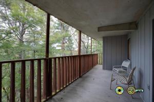 a balcony of a house with a chair and trees at Senedo Springs Condo #2-202 in Basye +21 photos