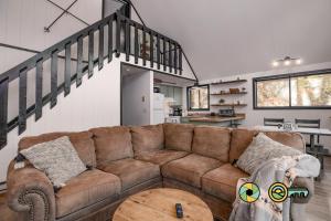 a living room with a brown couch and a staircase at 16 Deloris Road: Coppertop Chalet in Basye