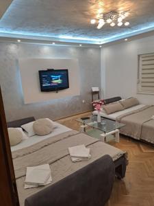 a living room with two beds and a flat screen tv at Apartment Vesna in Podaca