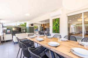 a dining room with a long table and chairs at Ensemble Villa et Studio Piscine Proche Plage in Valras-Plage