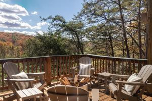 a deck with chairs and a table with a view at 210 Nelson Way: Par Pine Lodge in Basye