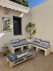 two benches sitting next to a wall with a mirror at Lamia Al Mar in Torre Canne