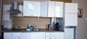 a kitchen with white cabinets and a sink at Résidence Bayard in Dinant