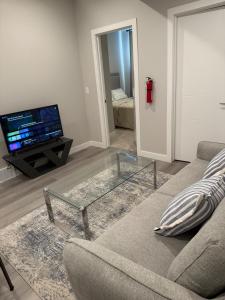 a living room with a couch and a glass coffee table at A place to call a home in YYC