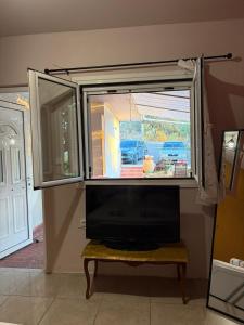 a window in a living room with a tv at Verga Olive Grove Studio in Kalamata
