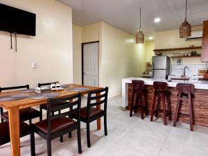a kitchen and dining room with a wooden table and chairs at Casa Melda Walk to the Beach & Gandoca-ManzanillO in Manzanillo
