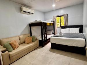 a bedroom with a bed and a couch at Casa Melda Walk to the Beach & Gandoca-ManzanillO in Manzanillo
