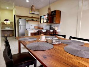 a kitchen and dining room with a wooden table at Casa Melda Walk to the Beach & Gandoca-ManzanillO in Manzanillo +16 photos