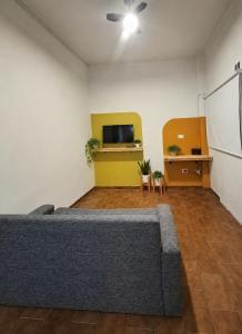 a living room with a couch and a tv at Departamento Abu Dolly in La Plata