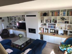 a living room with a blue couch and a table at Single-storey house in Saint-Cyr in Saint-Cyr-sur-Loire