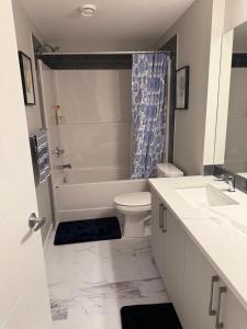 a bathroom with a tub and a toilet and a sink at A place to call a home in YYC