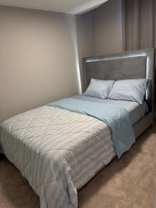 a bed with a silver headboard and white pillows at A place to call a home in YYC