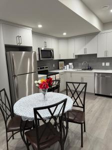 a kitchen with a table with a vase of flowers on it at A place to call a home in YYC +7 photos