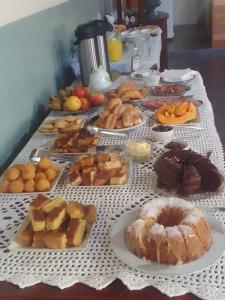 a table full of different types of pastries and desserts at Quartos na Montanha in Siderópolis
