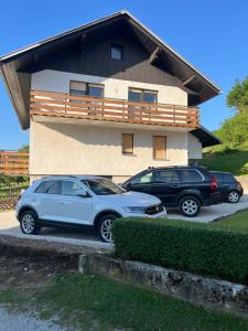 two cars parked in front of a house at Apartma Špan in Zgornje Gorje