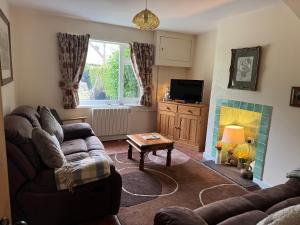 a living room with a couch and a table at Holly Farm Cottage in Flixton