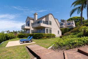 a blue bench in front of a large house at Villa L'Auberge in San Diego