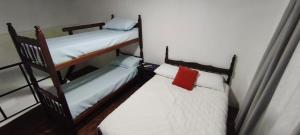 two bunk beds in a small room with a red pillow at El Refugio - Departamentos in Metán Viejo +21 photos