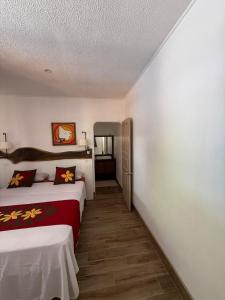 a hotel room with two beds and a hallway at Hiro'a - Fare Orotia in Taputapuapea