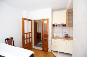 a kitchen with white cabinets and an open doorway at Apartmani Cebra & Lisa in Topla