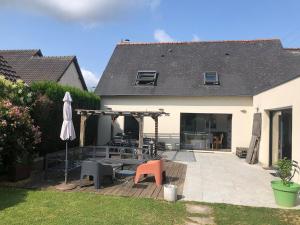 a patio with a table and chairs and an umbrella at Single-storey house in Saint-Cyr in Saint-Cyr-sur-Loire