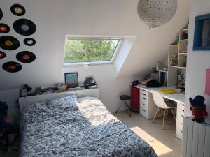 a bedroom with a bed and a desk and a window at Single-storey house in Saint-Cyr in Saint-Cyr-sur-Loire