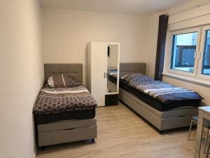 two beds in a room with a mirror at Worms City Suites Löwengasse in Worms