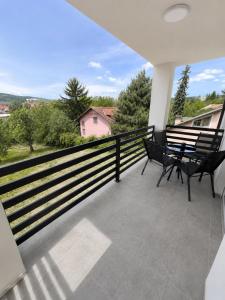 a balcony with two benches and a view at White House apartmani in Vrdnik