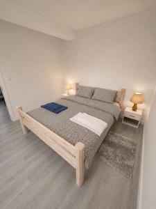 a large bed in a room with two night stands at White House apartmani in Vrdnik