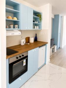 a kitchen with blue cabinets and a wooden counter top at White House apartmani in Vrdnik +8 photos
