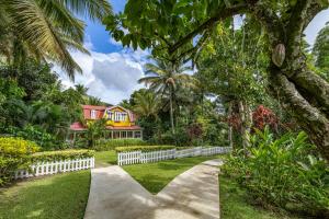 a driveway leading to a house with a white fence at Fond Doux Eco Resort in Soufrière