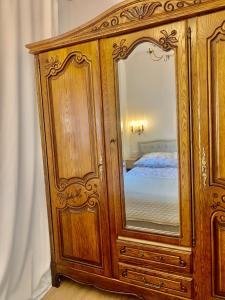 a wooden cabinet with a mirror in a bedroom at Lublin Aura Residence in Lublin