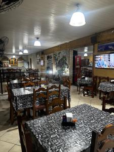 a restaurant with tables and chairs in a room at Pousada Natalino Broleze in Águas de Lindoia