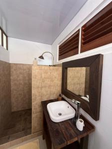 a bathroom with a sink and a mirror at Aremiti - Fare Orotia in Taputapuapea +39 photos