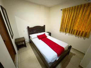a red and white bed in a room with a window at Hotel Tucan Pereira in Pereira