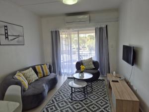 a living room with a couch and a table at Elegant Bliss -2 bedroomed at Dainfern, in Fourways, Sandton in Fourways
