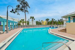 a swimming pool at a resort with blue water at New-Build with Pool Walk to Beach in Santa Rosa Beach