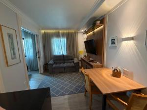 a living room with a table and a couch at Hotel Inter Jardins UH-2310 in São Paulo