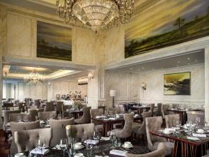 a restaurant with tables and chairs and a chandelier at Sofitel Xining in Xining