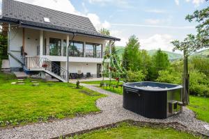 ein Haus mit einer großen Badewanne im Garten in der Unterkunft Infinity View Chalet in Valea Doftanei