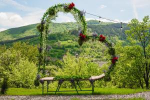 ein Blumenbogen mit Blumen auf einem Tisch auf einem Feld in der Unterkunft Infinity View Chalet in Valea Doftanei + 68 Fotos
