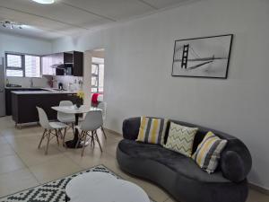 a living room with a couch and a table at Elegant Bliss -2 bedroomed at Dainfern, in Fourways, Sandton in Fourways
