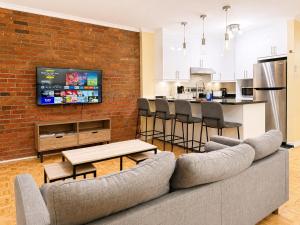 a living room with a couch and a brick wall at APARTMENT HOTEL ST-DENIS in Montreal