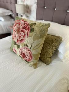 a pillow with flowers is sitting on a bed at The Royal George Cottingham in Cottingham +8 photos