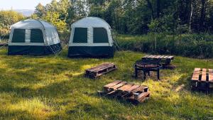 a group of tents and picnic tables in a field at Namioty w lesie in Ściegny +17 photos
